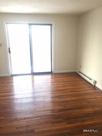 a view of empty room with wooden floor