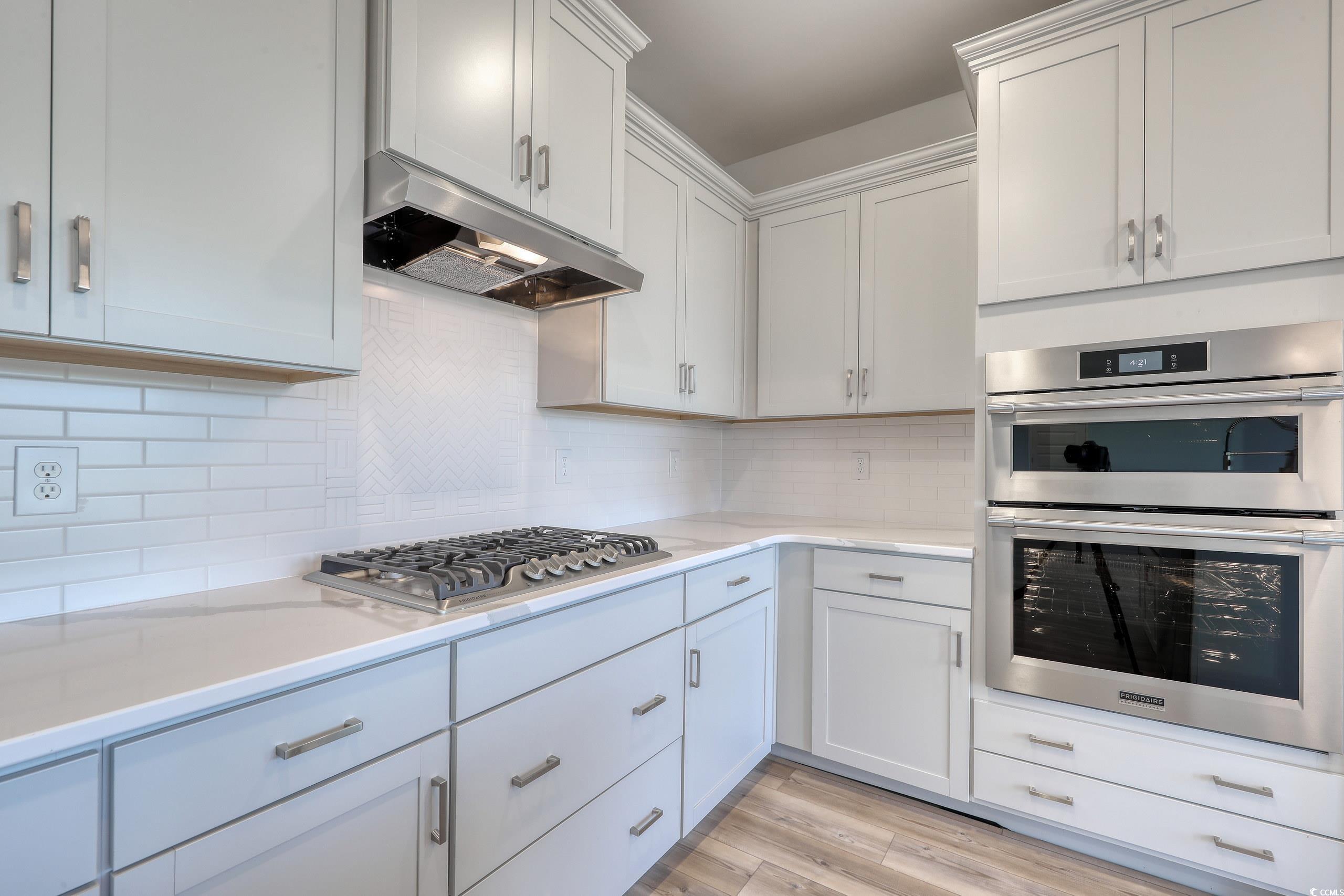 771 Enchantment Loop Myrtle Beach, SC 29588 - Photo 7 of 40 Kitchen with white cabinetry, appliances with stai