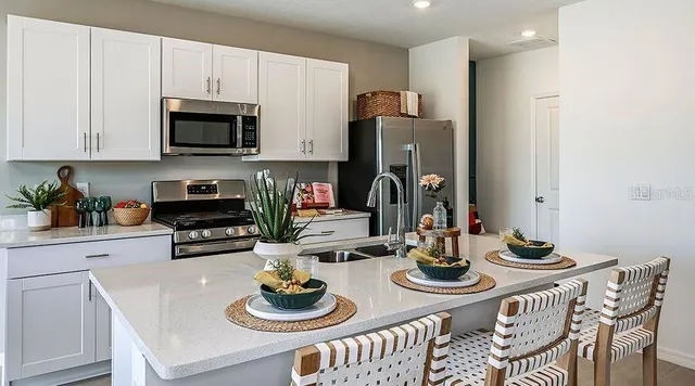 a kitchen with stainless steel appliances a dining table and chairs