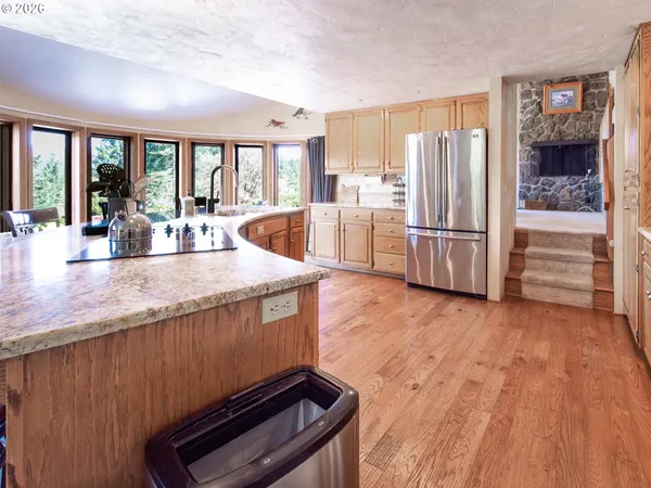 a kitchen with stainless steel appliances granite countertop a refrigerator a stove and a wooden floors