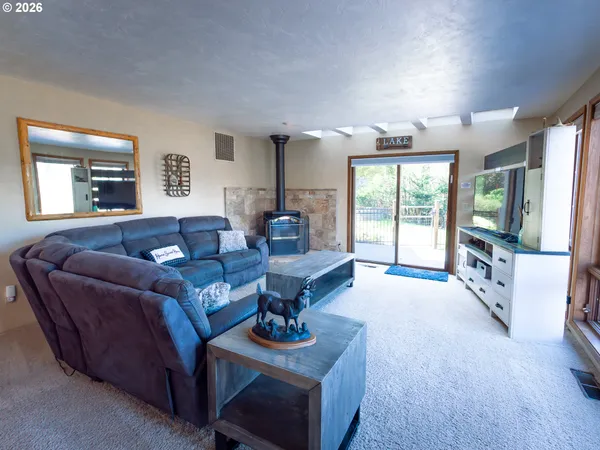 a living room with furniture a flat screen tv and a large window