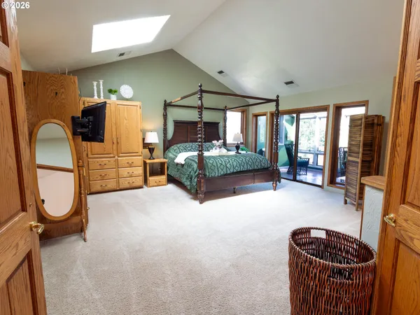 a spacious bedroom with a bed and dresser with mirror