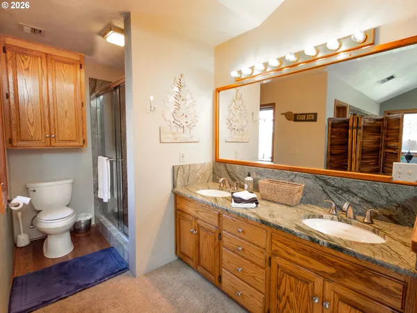 a bathroom with a granite countertop sink toilet and shower