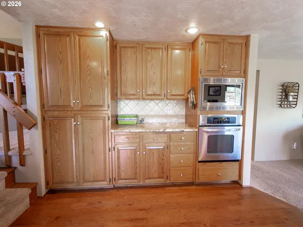 a kitchen with stainless steel appliances granite countertop a refrigerator and a stove top oven