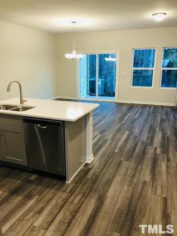 a large kitchen with stainless steel appliances wooden cabinets and a stove top oven