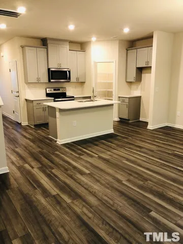 a kitchen with stainless steel appliances a sink stove and microwave