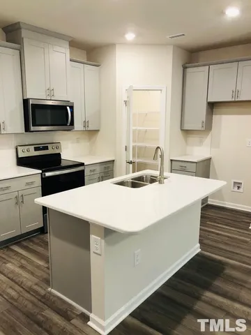 a view of a room with a sink and a ceiling fan