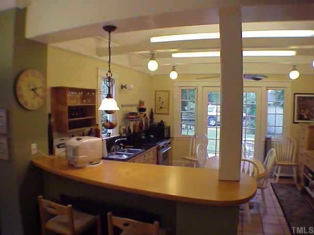 311 Cutler Street Raleigh, NC 27603 - Photo 4 of 10 The kitchen is hip with a curved counter top, tile floors, a vaulted ceiling and lots of lights. Other