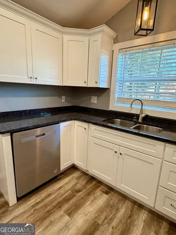 a kitchen with granite countertop white cabinets and appliances