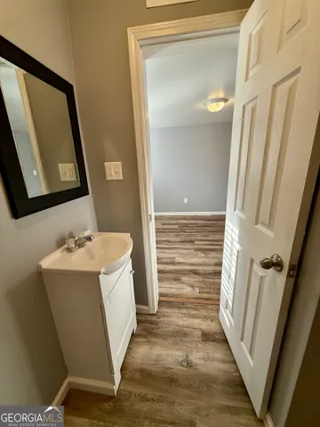 a view of a hallway with wooden floor and staircase