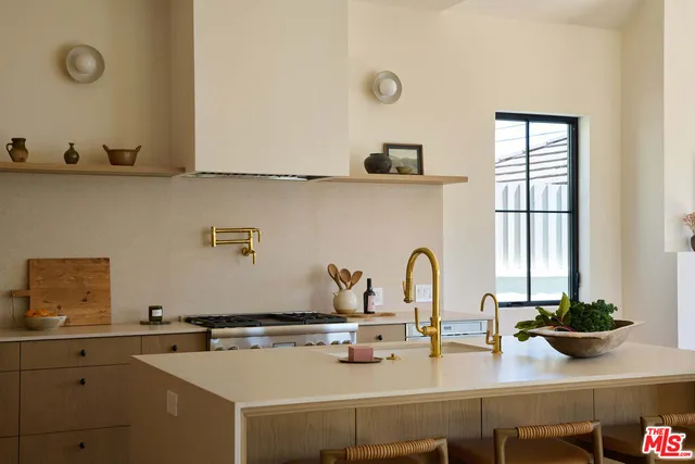 a kitchen with stainless steel appliances a stove a sink and white cabinets