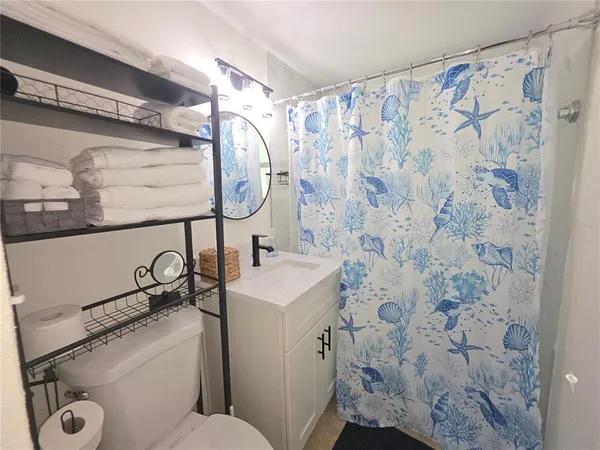 a bathroom with a sink and mirror with toilet