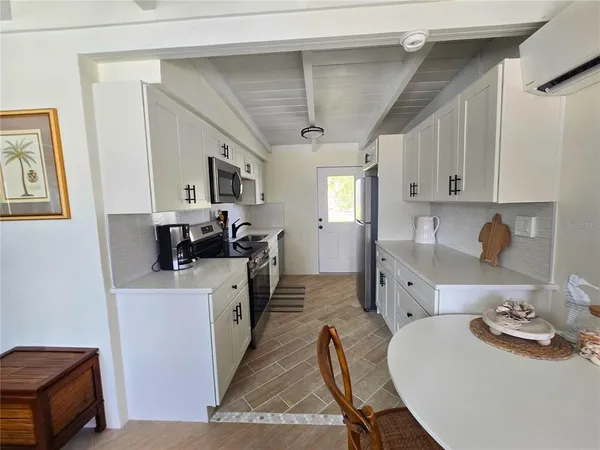a kitchen that has a lot of cabinets in it and wooden floors