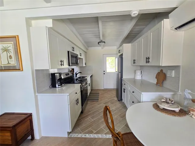 a kitchen that has a lot of cabinets in it and wooden floors