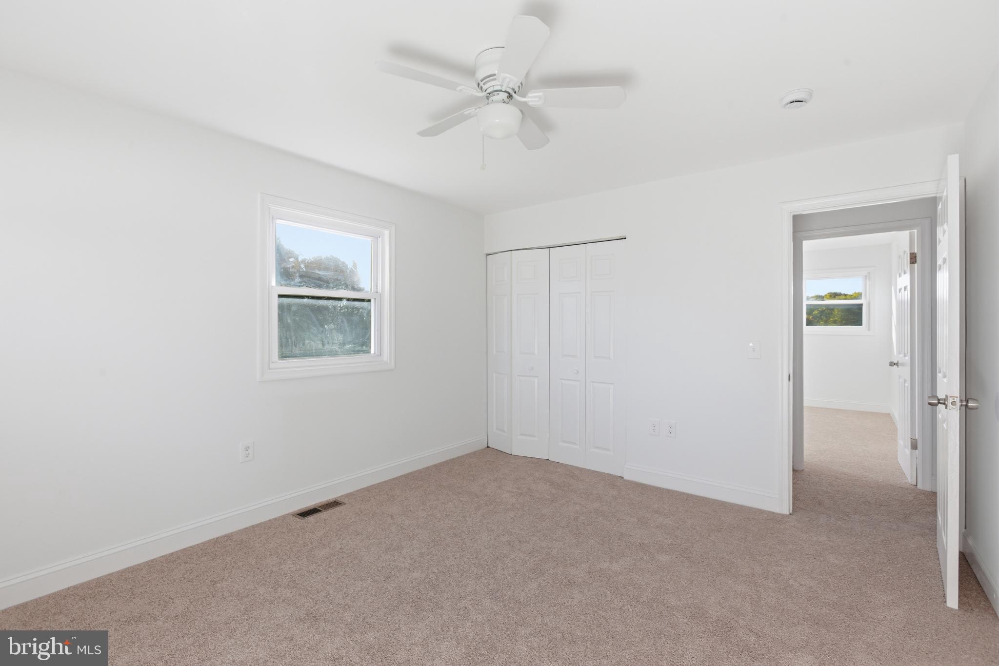 1826 Hanson Road Edgewood, MD 21040 - Photo 11 of 22 an empty room with a chandelier fan and windows