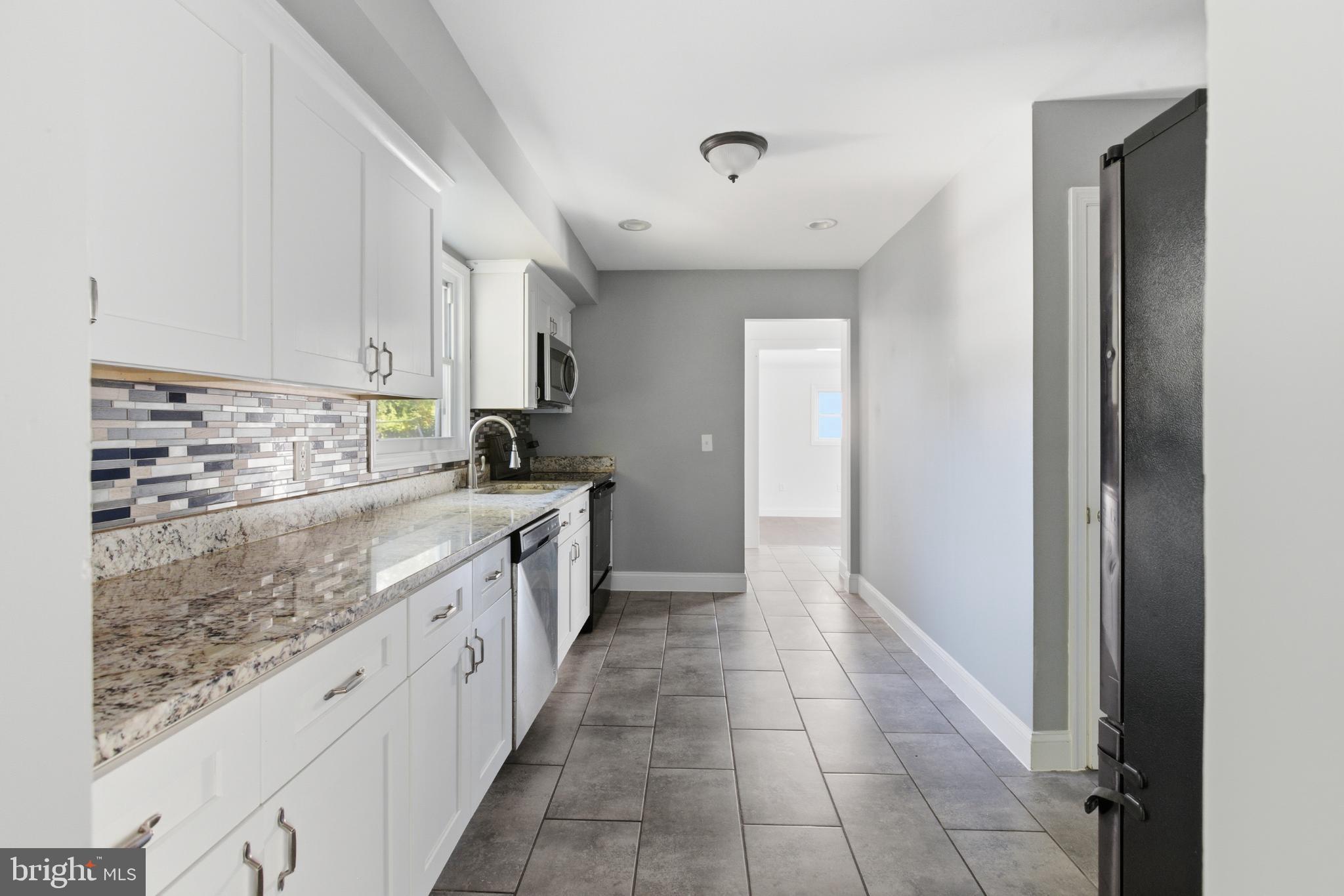 1826 Hanson Road Edgewood, MD 21040 - Photo 6 of 22 a large kitchen with kitchen island granite countertop a sink window and cabinets