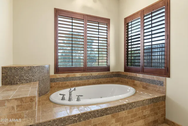 a view of an empty room with window and a kitchen