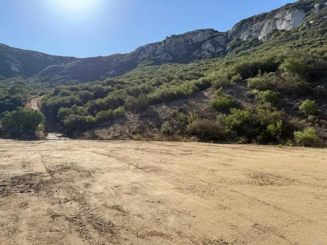 a view of a dry yard with mountains in the background