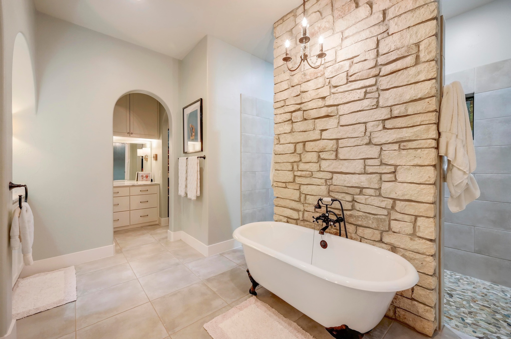 401 Trail Ridge Road Wimberley, TX 78676 - Photo 11 of 34 Full bathroom featuring a freestanding tub, walk in shower, light tile patterned floors, vanity, and a chandelier