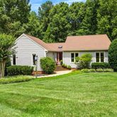 a front view of a house with a yard and trees
