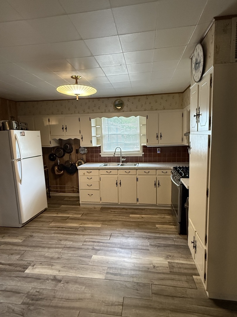407 Middleton Street Iuka, IL 62849 - Photo 6 of 14 a kitchen with stainless steel appliances granite countertop a sink a stove a refrigerator and island with wooden floor