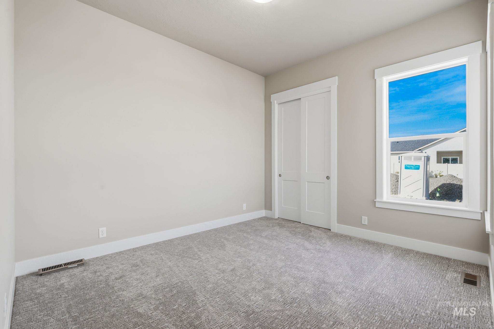 470 South Radiator Way Boise, ID 83716 - Photo 34 of 50 Neutral-toned room featuring a large window, light gray carpeting, and a double-door closet with white trim