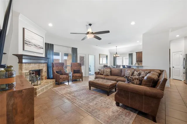a living room with furniture a fireplace and a ceiling fan