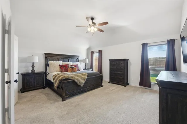a spacious bedroom with a bed and a chandelier