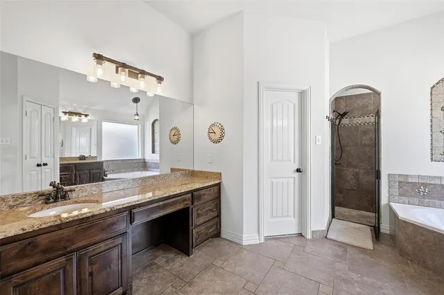 a spacious bathroom with a granite countertop sink a mirror and shower