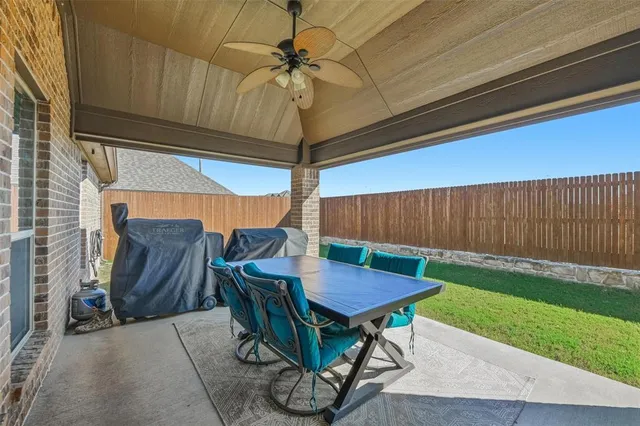 a view of a house with a yard and a large tree