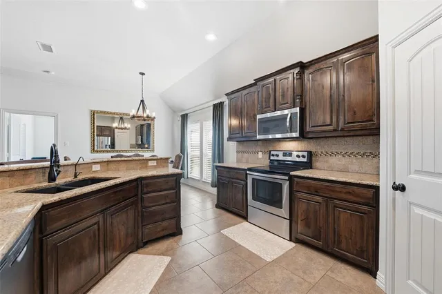 a kitchen with stainless steel appliances granite countertop a sink and stove top oven