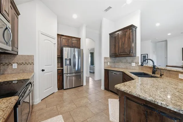 a kitchen with stainless steel appliances granite countertop a sink stove and refrigerator