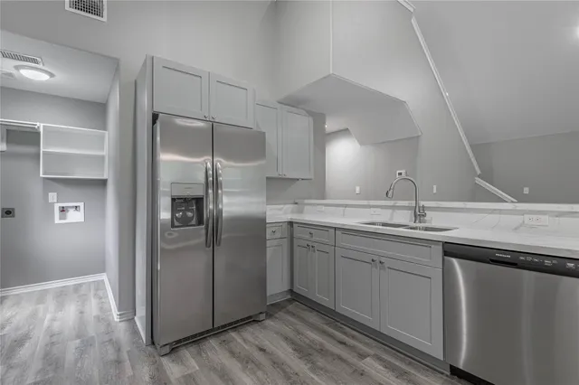 a kitchen with stainless steel appliances granite countertop a sink and refrigerator