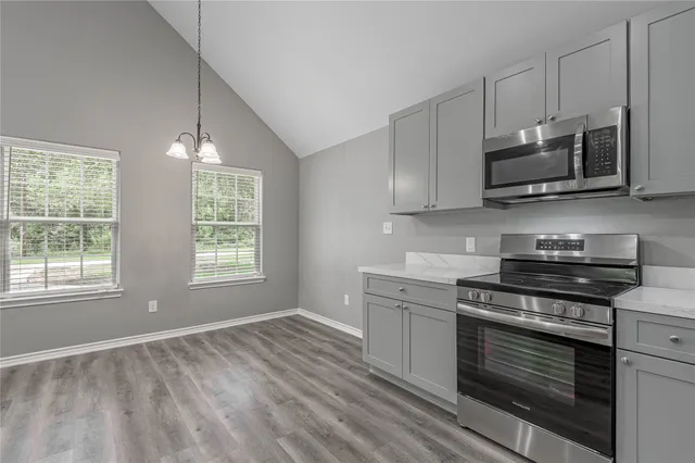 a kitchen with stainless steel appliances a stove a microwave and cabinets