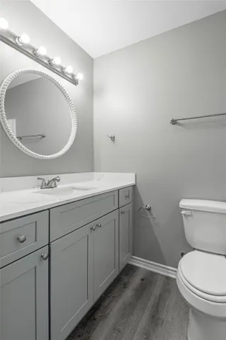 a bathroom with a toilet a sink and mirror