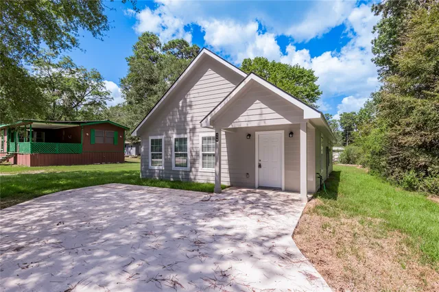 a view of a house with a yard and potted plants