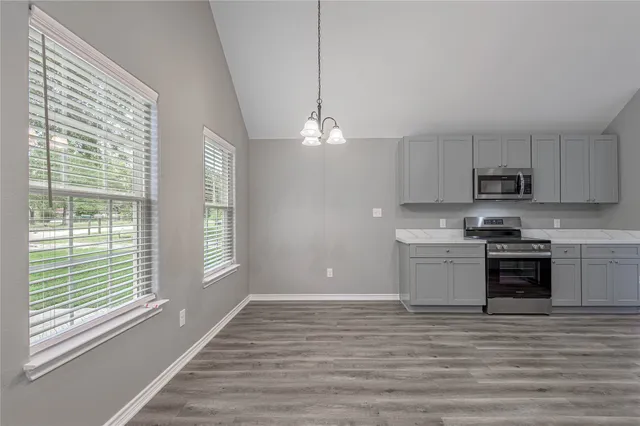 a kitchen with stainless steel appliances granite countertop a stove a sink and a refrigerator