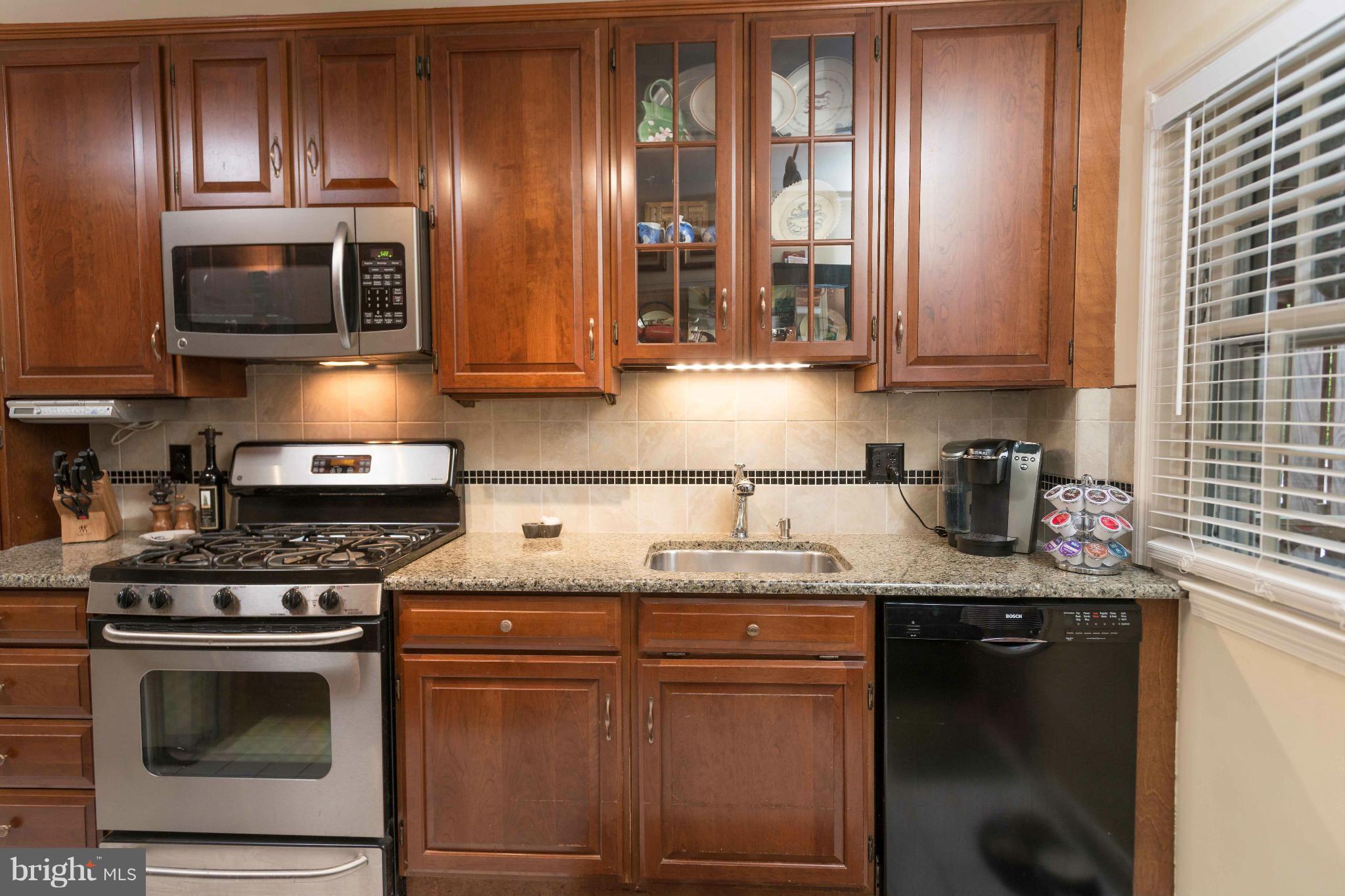6420 Pinehurst Road Baltimore, MD 21212 - Photo 9 of 30 a kitchen with stainless steel appliances granite countertop a stove a sink and a microwave
