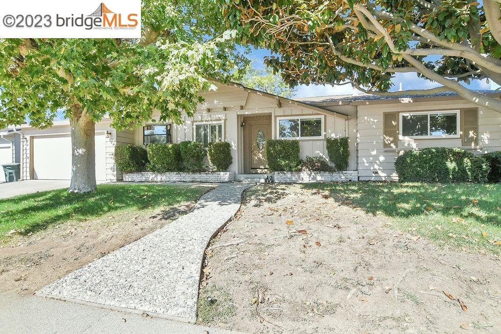 a front view of a house with a yard and potted plants