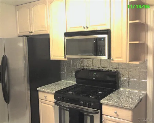a kitchen with stainless steel appliances granite countertop white cabinets and a stove