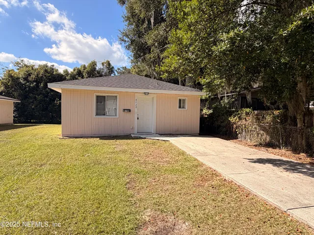 a front view of house with yard and trees around