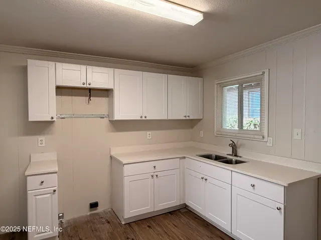 a kitchen with white cabinets and white appliances