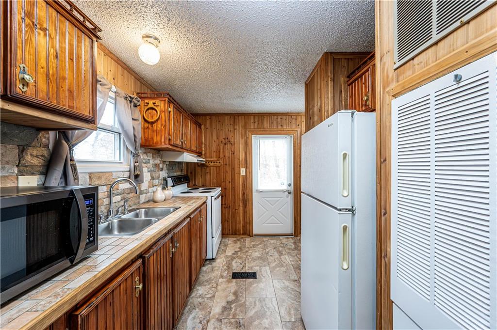 303 Mt Manor Road Manor, PA 15665 - Photo 21 of 43 THERE IS A GALLEY KITCHEN IN THE HOME WITH A LAUNDRY ROOM AT THE RIGHT NEAR THE SIDE DOOR