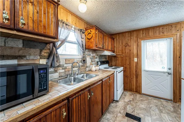 a bathroom with a granite countertop sink a toilet and shower