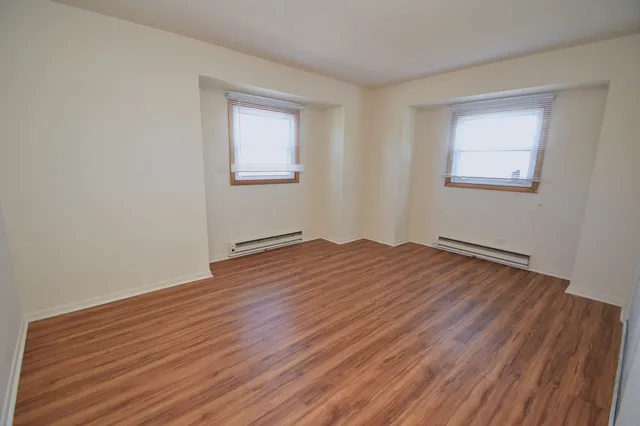 a view of a room with wooden floor and white walls