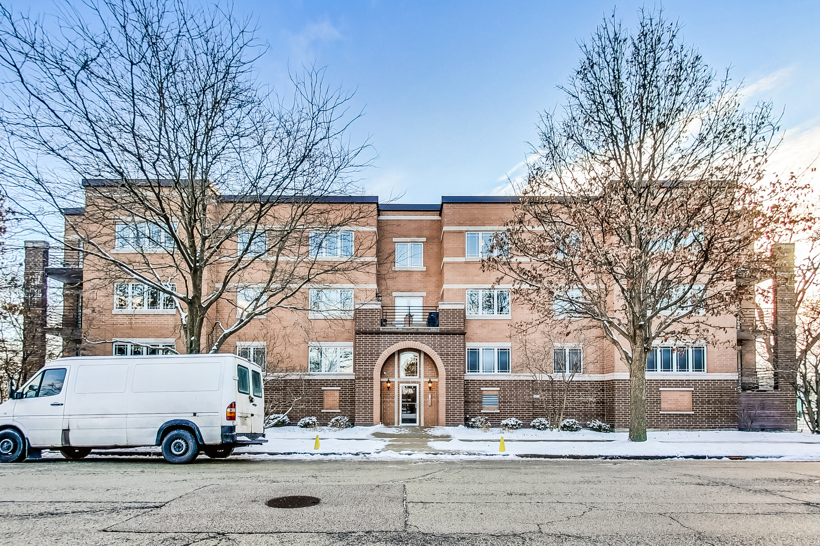a white building that has a tree in front of it