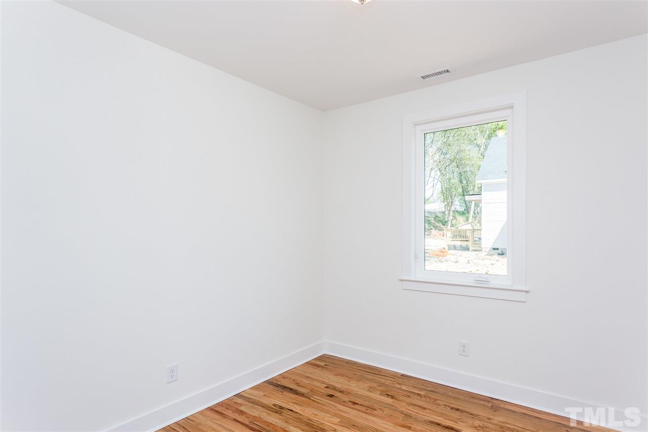 811 Postell Street Raleigh, NC 27601 - Photo 14 of 20 an empty room with wooden floor and windows