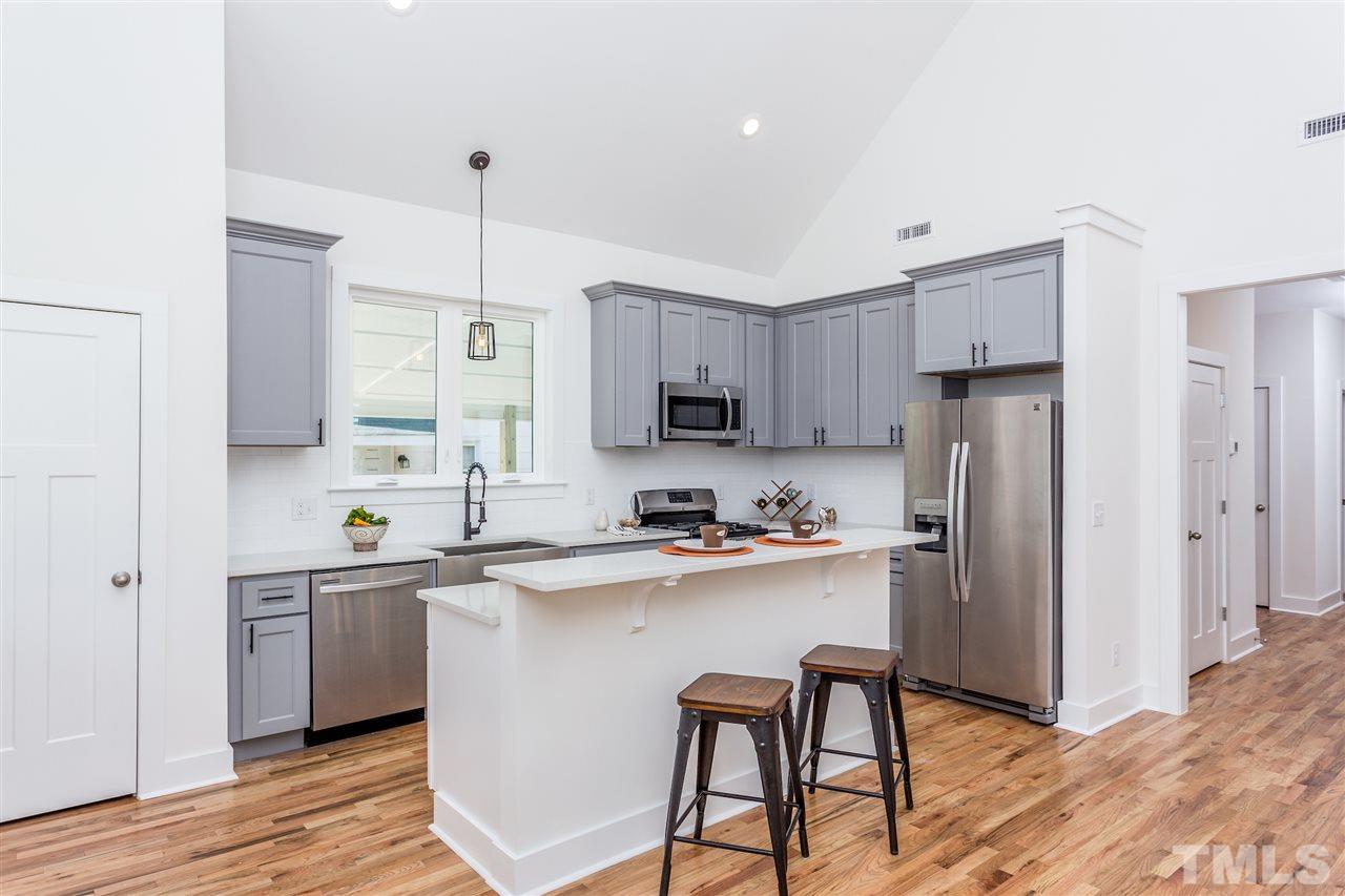 811 Postell Street Raleigh, NC 27601 - Photo 5 of 20 a kitchen with stainless steel appliances a sink a stove a refrigerator cabinets and wooden floor
