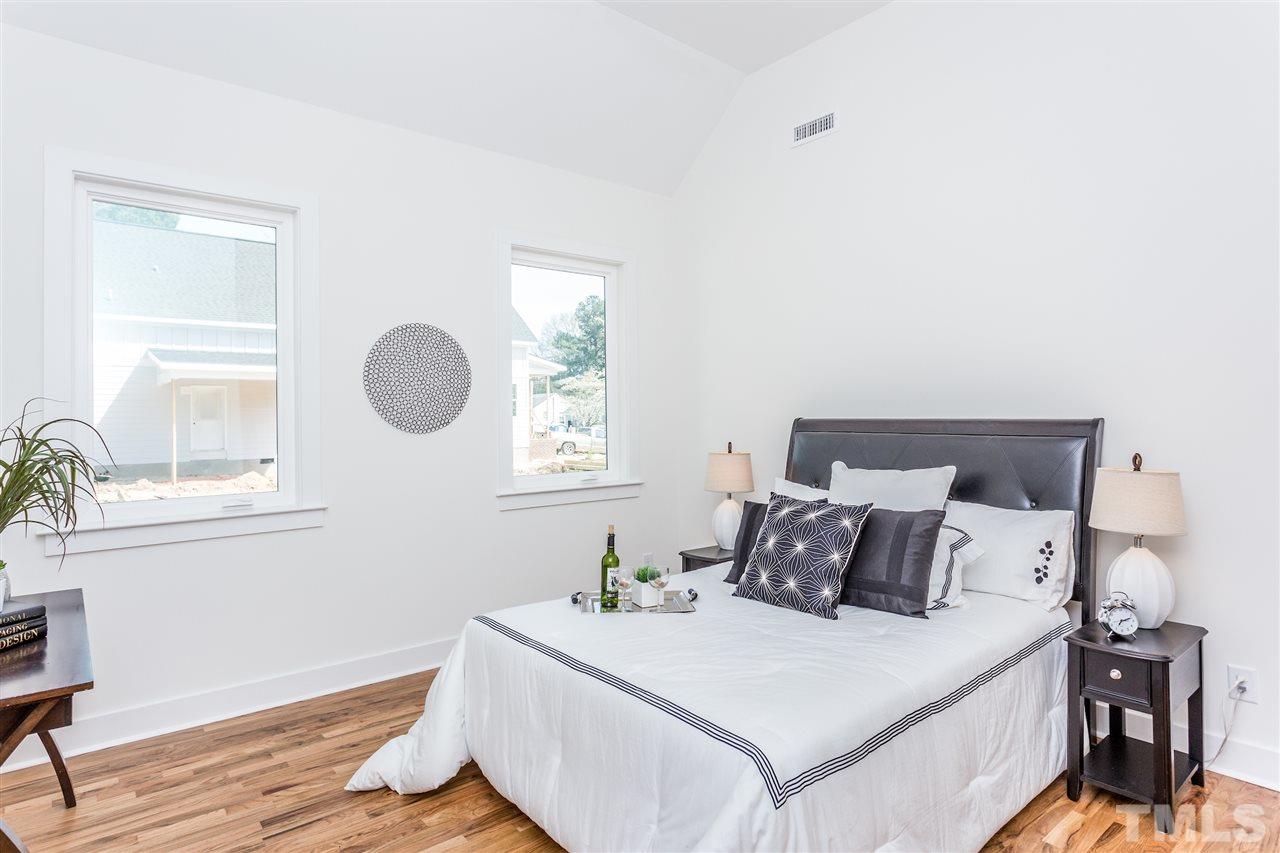 811 Postell Street Raleigh, NC 27601 - Photo 10 of 20 a bedroom with a bed and wooden floor