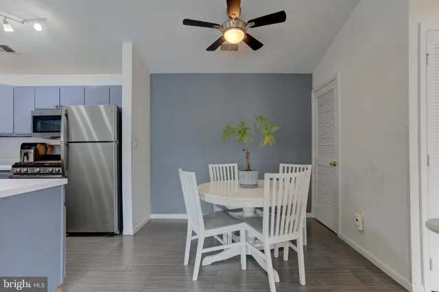 a dining room with furniture and a refrigerator